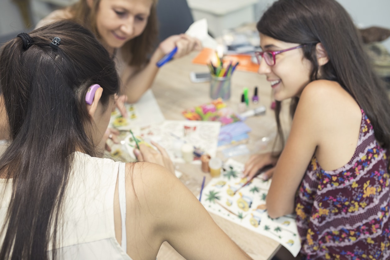 Teenage girl with a hearing aid hanging out with her friends