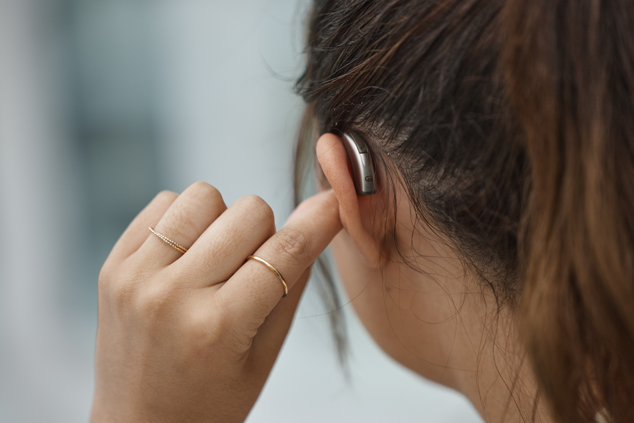Rear shot of a hearing aid in a woman's ear.
