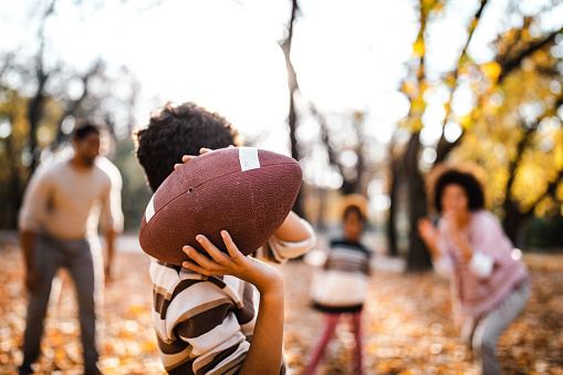 Family playing football on a fall day.